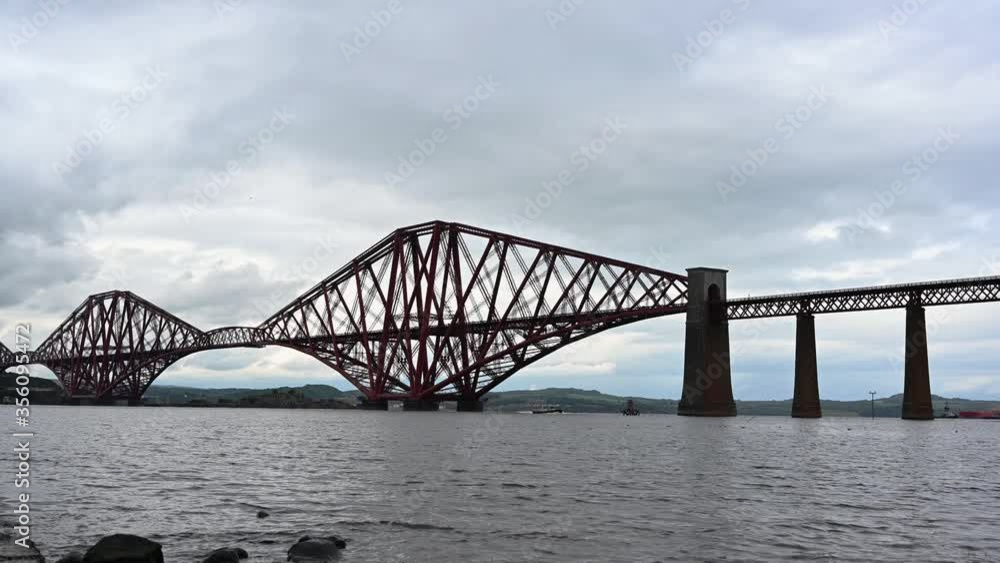 Boat crossing under the Forth Bridge, Scotland Boat crossing under the Forth Bridge, Scotland