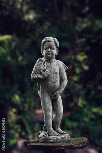 statue of a Menneken Pis in a garden include clipping path