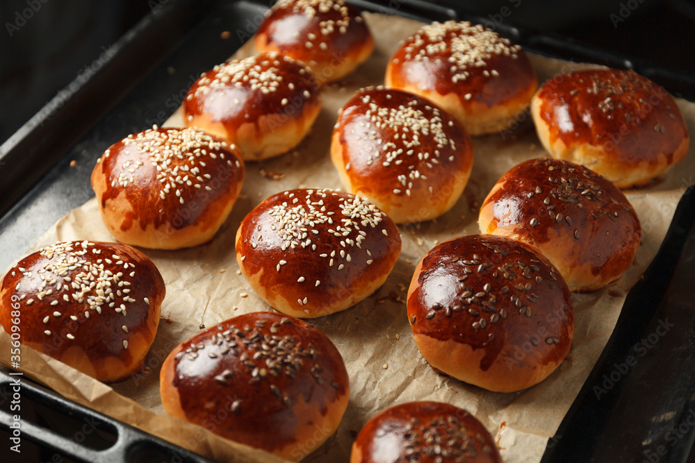 Fresh hot sweet buns with sesame seeds from the oven, homemade bakery. Fresh hot sweet buns with sesame seeds from the oven, homemade bakery.