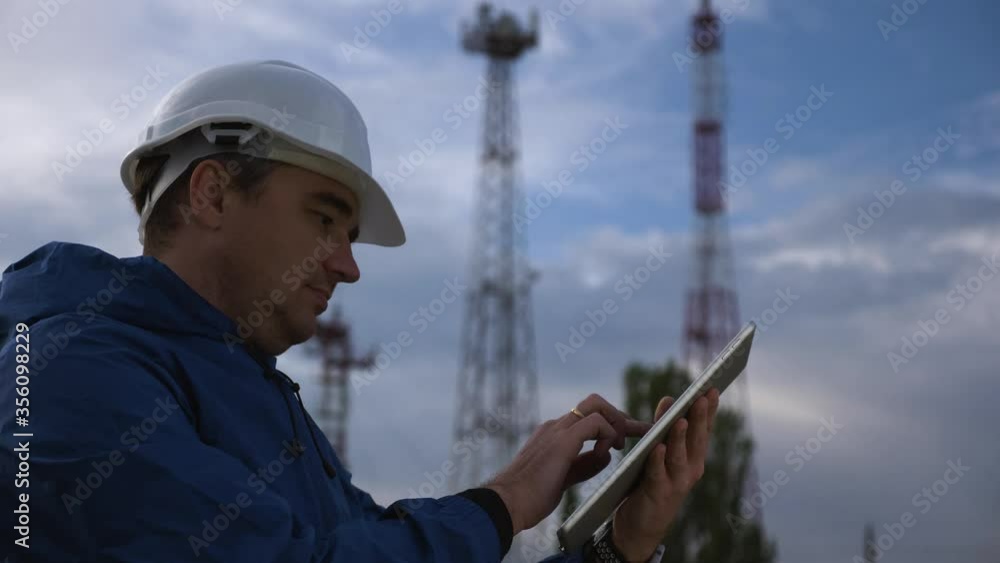A telecommunications engineer working on a digital tablet records data for maintenance of the telecommunications network. Design, repair and installation of satellite and telecommunications networks. A telecommunications engineer working on a digital tablet records data for maintenance of the telecommunications network. Design, repair and installation of satellite and telecommunications networks.