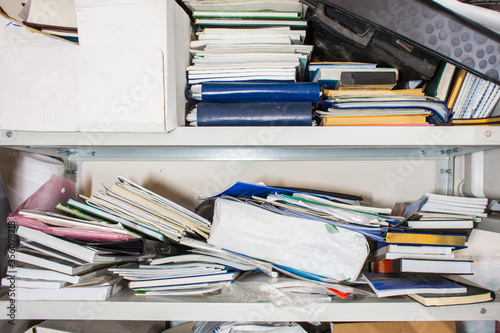 Obraz na plátne Declutter concept - lots of books, papers, boxes on shelf - chaos, clutter, mess