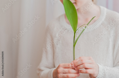 A delicate white flower in a girl's hand. Romantic composition.