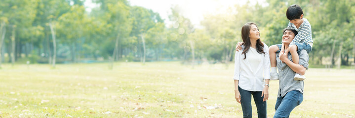 Happy young family spending time together outside in green nature and park, vacation of parents concept