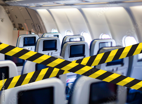 Flights prohibited. Social distancing warning sign in airplane cabin without passengers. Coronavirus disease COVID-19 new travel rules. Keep social in aircraft.