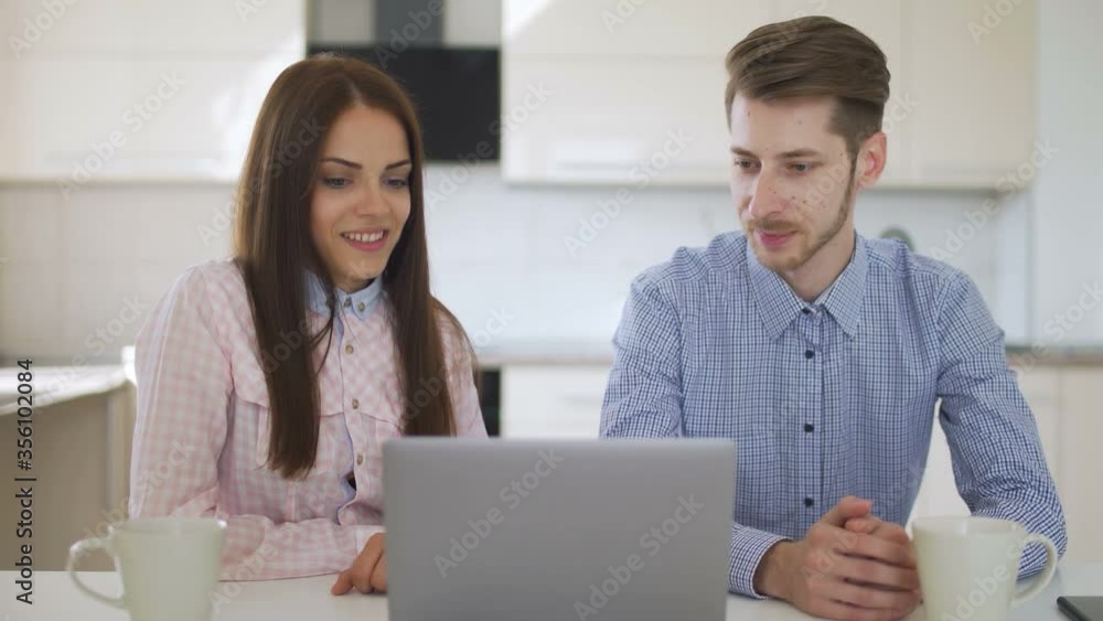 Couple are using notebook to shopping online at kitchen Couple are using notebook to shopping online at kitchen
