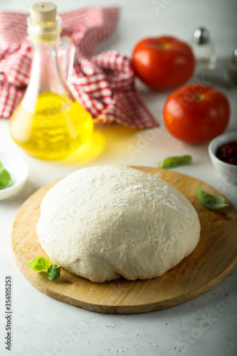 Traditional homemade pizza dough on a wooden desk