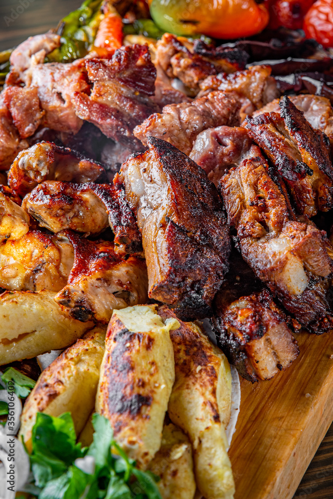 Assorted Mixed different grilled meat with vegetables on table Assorted Mixed different grilled meat with vegetables on table