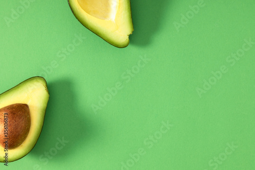 Avocado minimal pattern. Border made of green avocado on light green background. Flat lay, top view, copy space photo