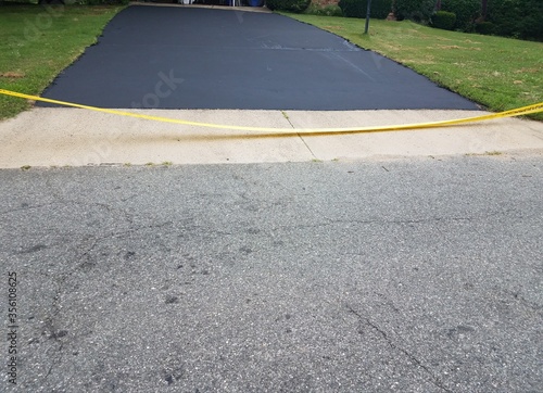 new asphalt driveway and yellow caution tape © Justin