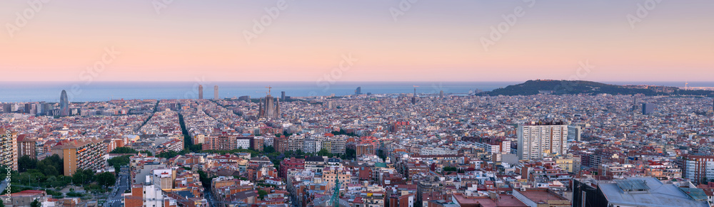 Panorama View over Barcelona Skyline at the blue hour after sunset. Spanish touristy city full of famous buildings, beautiful sea and monuments
