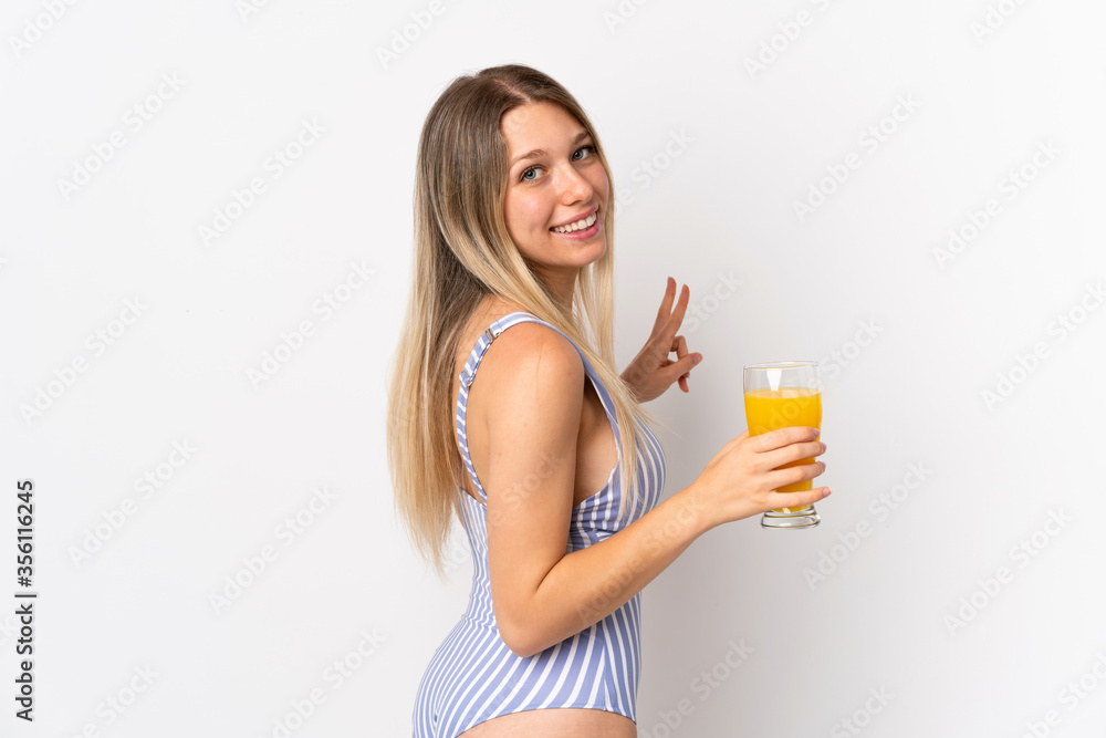Young blonde woman isolated on white background in swimsuit and holding a cocktail Young blonde woman isolated on white background in swimsuit and holding a cocktail