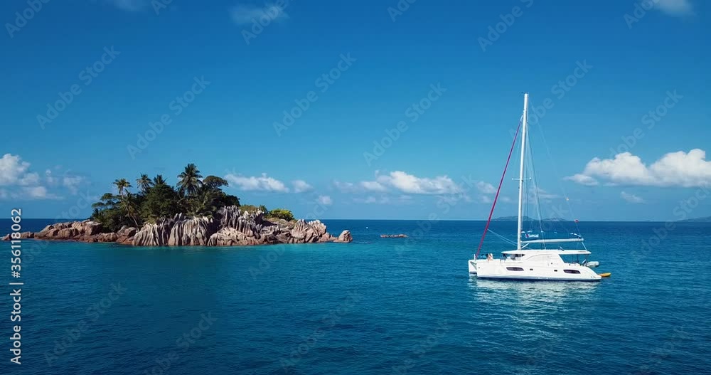 Saint Pierre, Seychelles - January 30, 2020: 4K Aerial Footage of the White Yacht near St. Pierre Island surrounding Blue Water of the Indian Ocean Saint Pierre, Seychelles - January 30, 2020: 4K Aerial Footage of the White Yacht near St. Pierre Island surrounding Blue Water of the Indian Ocean
