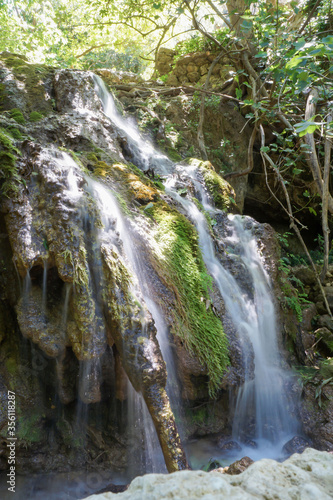 long exposure photo of a small waterfall over mossy rocks