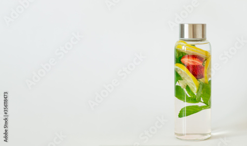 lemon, strawberry, mint flavored infused water. Summer refreshing drink. Health care, fitness, healthy nutrition diet detox concept. White background, copy space.