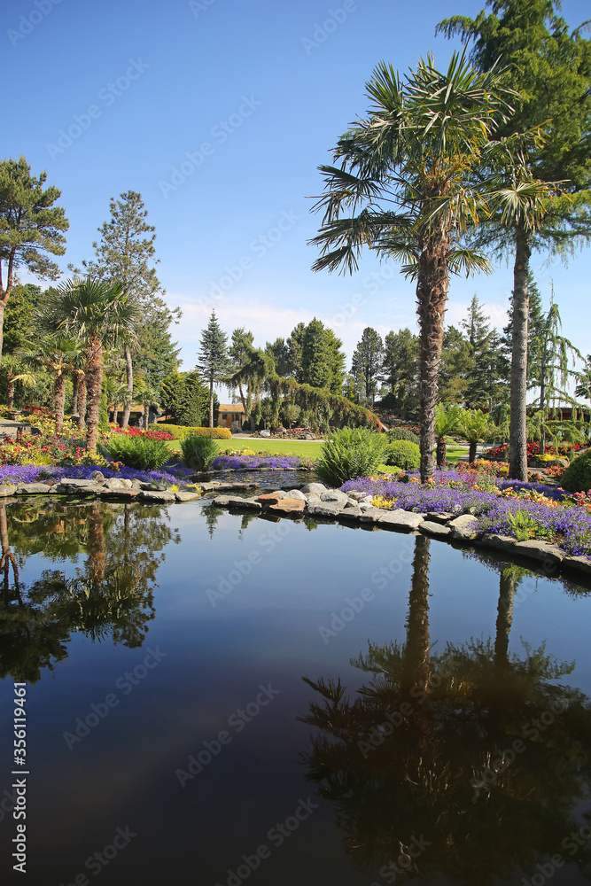 Reflections in the water at beautiful landscape with plants, flowers, trees, gardens on the islands outside Stavanger, Norway.