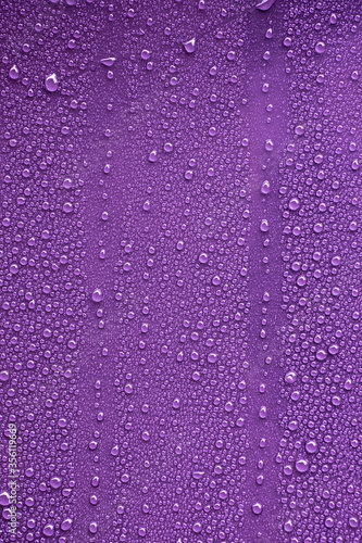 Raindrops on purple metal surface