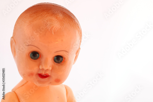 Vászonkép Creepy old doll with sinister eyes looking threateningly from the side