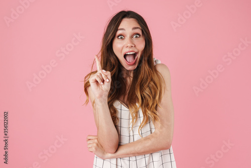 Image of excited woman expressing surprise and pointing finger upward