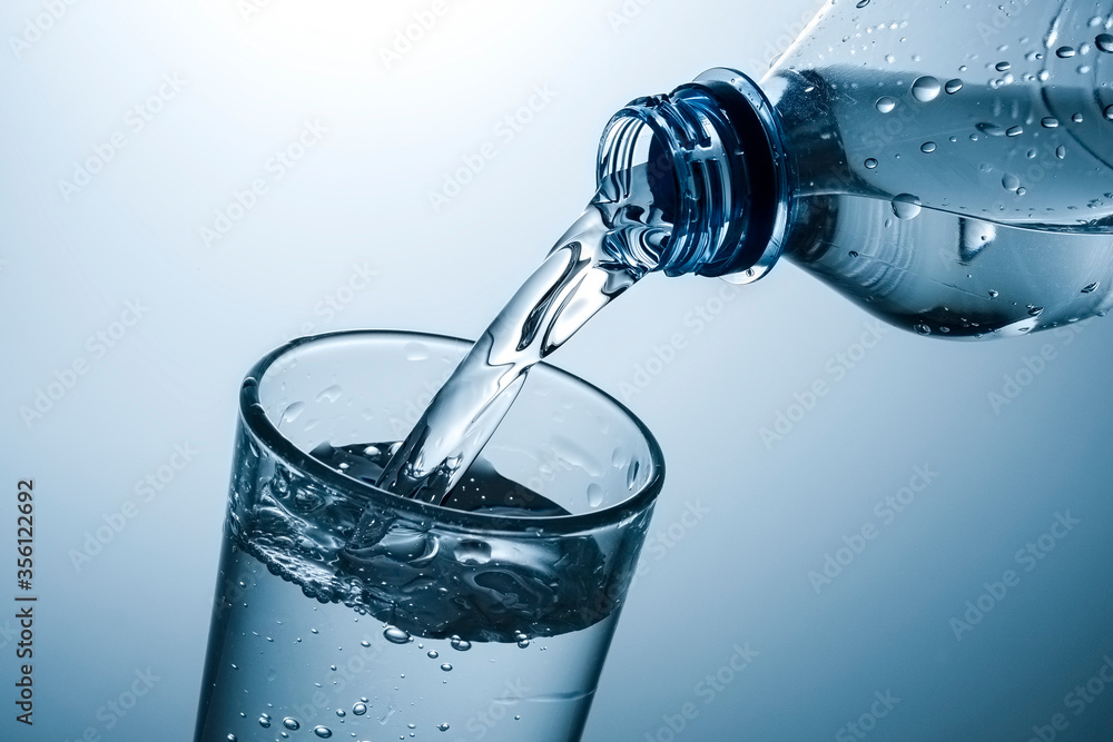 Sparkling water being poured into a tall glass Sparkling water being poured into a tall glass