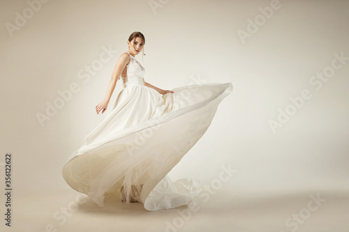 girl in a white satin dress with lace on a white background