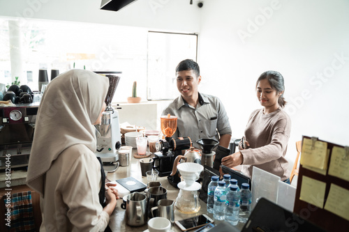 Barista receives orders from customers in the coffee shop
