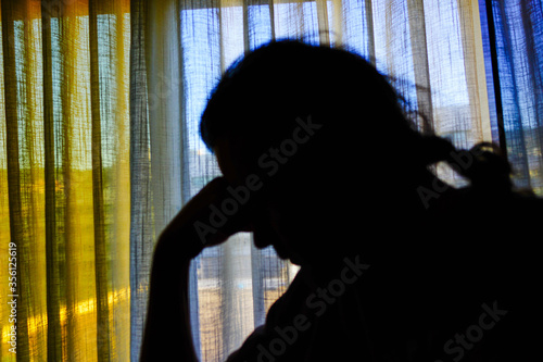 Silhouette of a man on background of window.