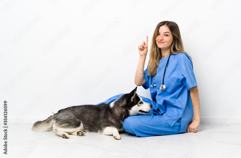 Veterinary doctor with Siberian Husky dog sitting on the floor pointing with the index finger a great idea