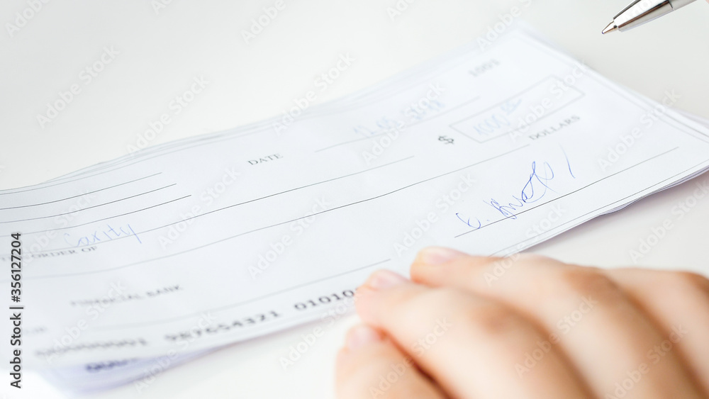Closeup image of filled and signed banking cheque Closeup image of filled and signed banking cheque