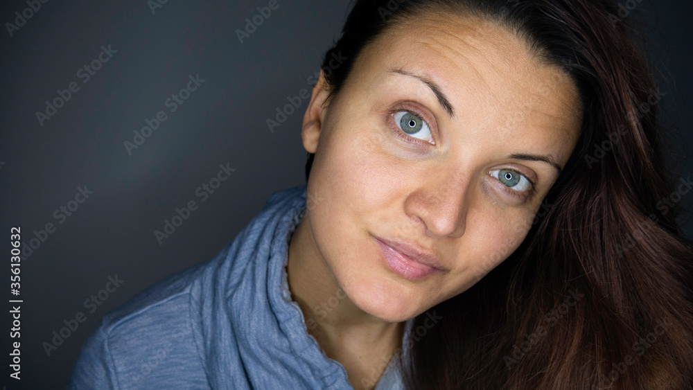 Close up portrait of a young Caucasian woman with green eyes in a blue hoodie. Close up portrait of a young Caucasian woman with green eyes in a blue hoodie.
