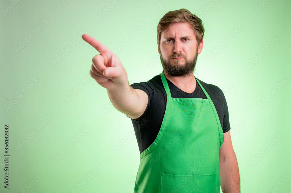 Supermarket employee with green apron and black t-shirt showing no with her finger Supermarket employee with green apron and black t-shirt showing no with her finger