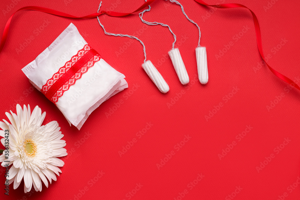 The concept of protection during menstruation. Gaskets and tampons on a red background. Copy space The concept of protection during menstruation. Gaskets and tampons on a red background. Copy space