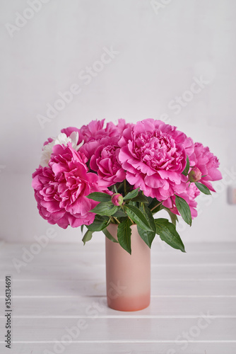 Peony bouquet in vase. Rich bunch of peonies. Greeting card for mother's day. Women's Day. Valentine's Day. Copy space. Spring or summer greeting card with flowers.Wedding invitation.Happy Birthday