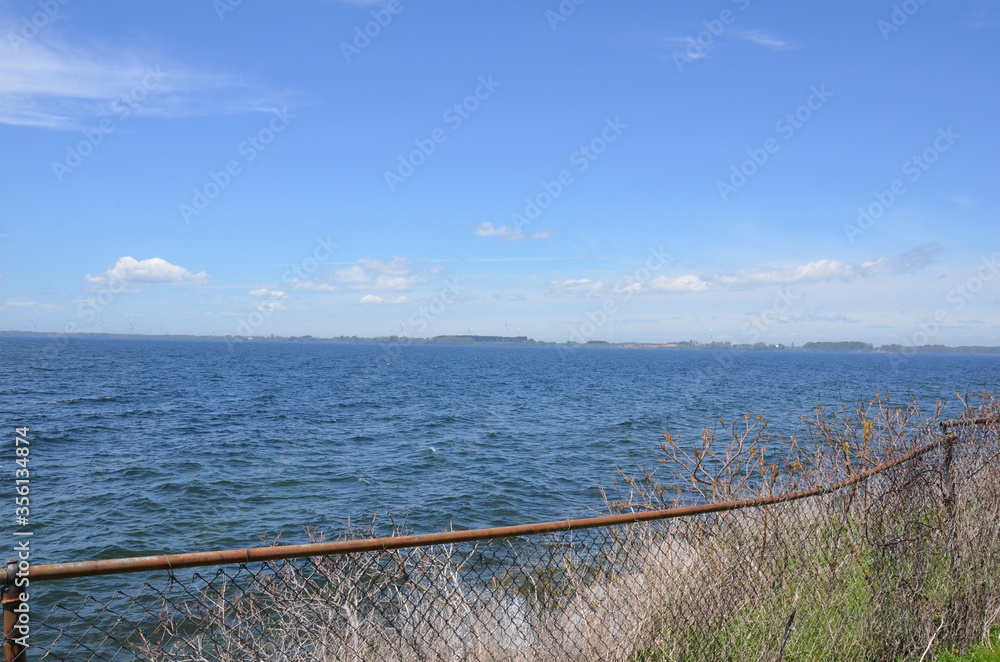 metal chain link fence with ocean water and sky