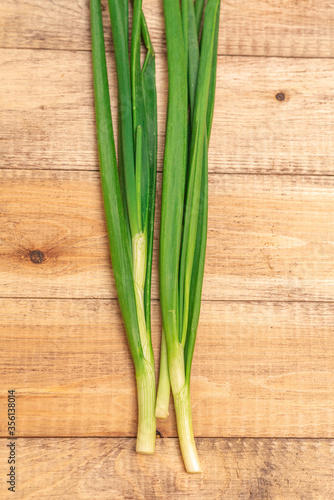 Tasty and fragrant green onions on a wooden table. Healthy food