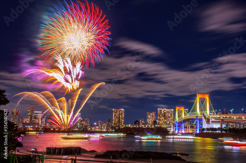 Odaiba, Tokyo, Beautiful and colorful firework with rainbow bridge and Tokyo city night view, event every summer and winter. This set firework presented in red yellow orange and purple glowing light. 