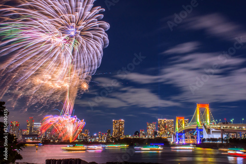 Odaiba, Tokyo, Beautiful and colorful firework with rainbow bridge and Tokyo city night view, event every summer and winter. This set firework presented in yellow orange and purple light. 