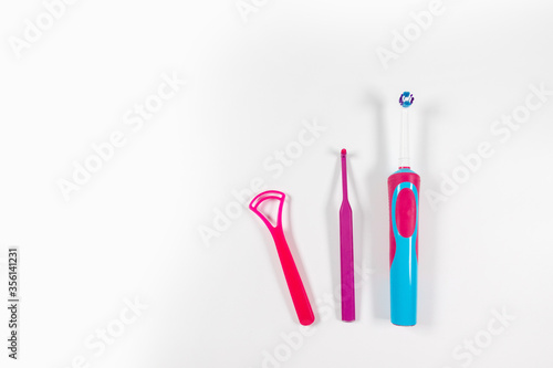 Ultrasonic pink toothbrush and dental hygiene products on a grey background. Dental products for brush teeth, healthy teeth care and oral hygiene