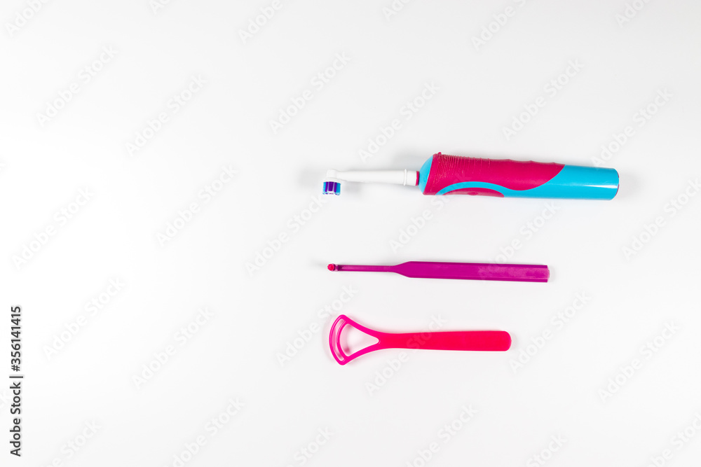 Ultrasonic pink toothbrush and dental hygiene products on a grey background. Dental products for brush teeth, healthy teeth care and oral hygiene Ultrasonic pink toothbrush and dental hygiene products on a grey background. Dental products for brush teeth, healthy teeth care and oral hygiene