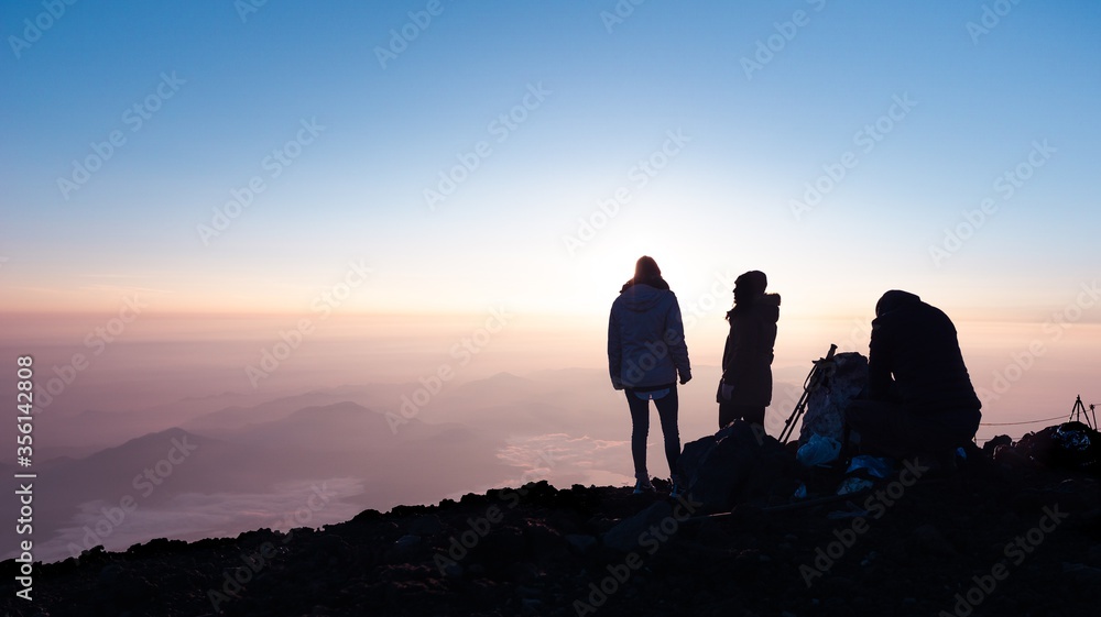 Silhouettes of people on a mountain sunrise