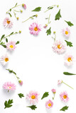 flower frame layout. beautiful pink chrysanthemums and green leaves on a white background. flat lay, vertical frame, copy space