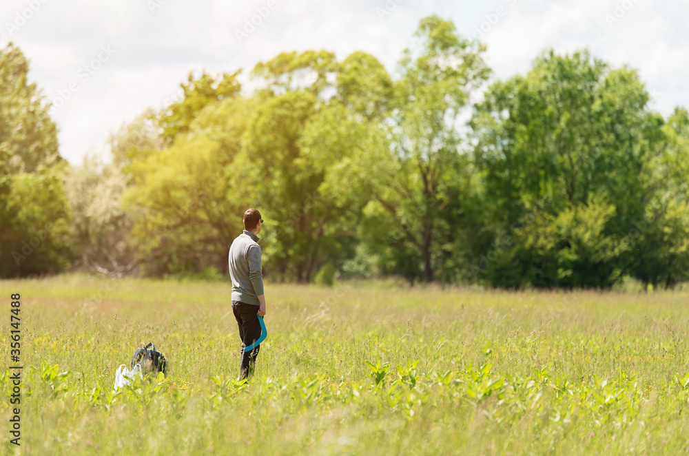 Man standing in the meadow with a boomerang in his hand Man standing in the meadow with a boomerang in his hand