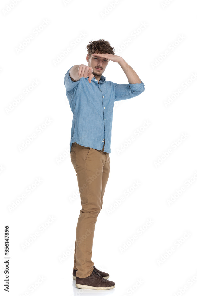 casual man holding hand to forehead and pointing finger casual man holding hand to forehead and pointing finger