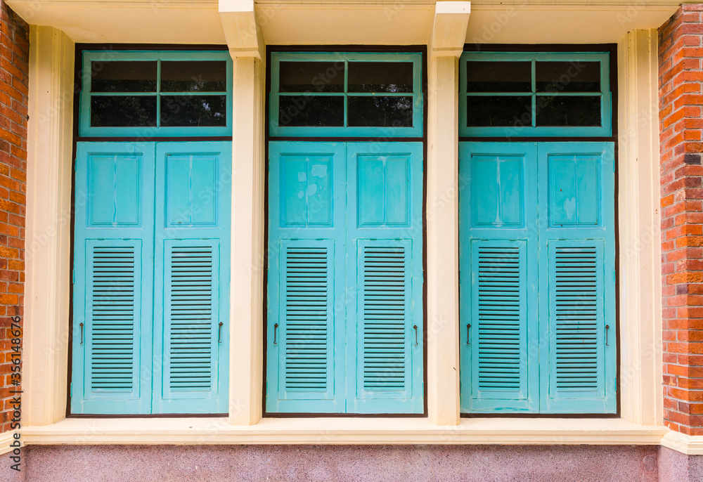 Fototapeta premium Old blue turquoise vintage wooden shutter windows with brick wall