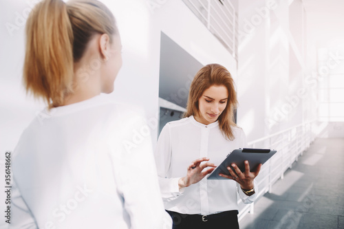 Female skilled office worker use digital tablet for consulting with managing director