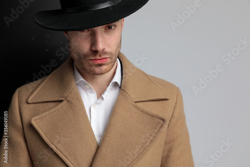 young fashion model in longcoat wearing hat photo