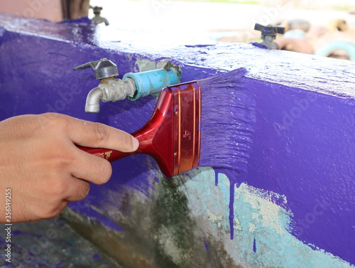 Wallpaper Mural Workers holding a paintbrush painted in purple repairing the old damaged color Torontodigital.ca