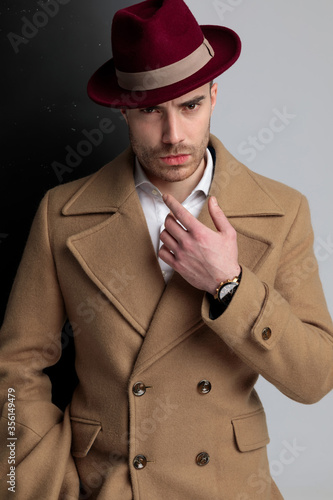 young fashion model in long coat pointing finger