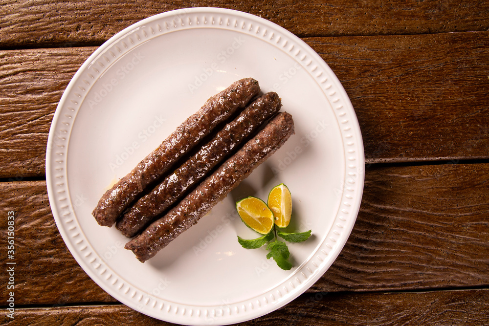 Traditional meat kafta from Arab cuisine on a white plate Traditional meat kafta from Arab cuisine on a white plate