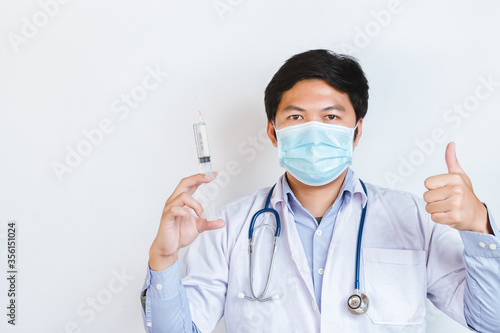 Doctor wearing medical face mask  studio portrait. Doctor  Wearing Protective Mask and showing thumb up. Doctor  wearing surgical mask for corona virus  copy space