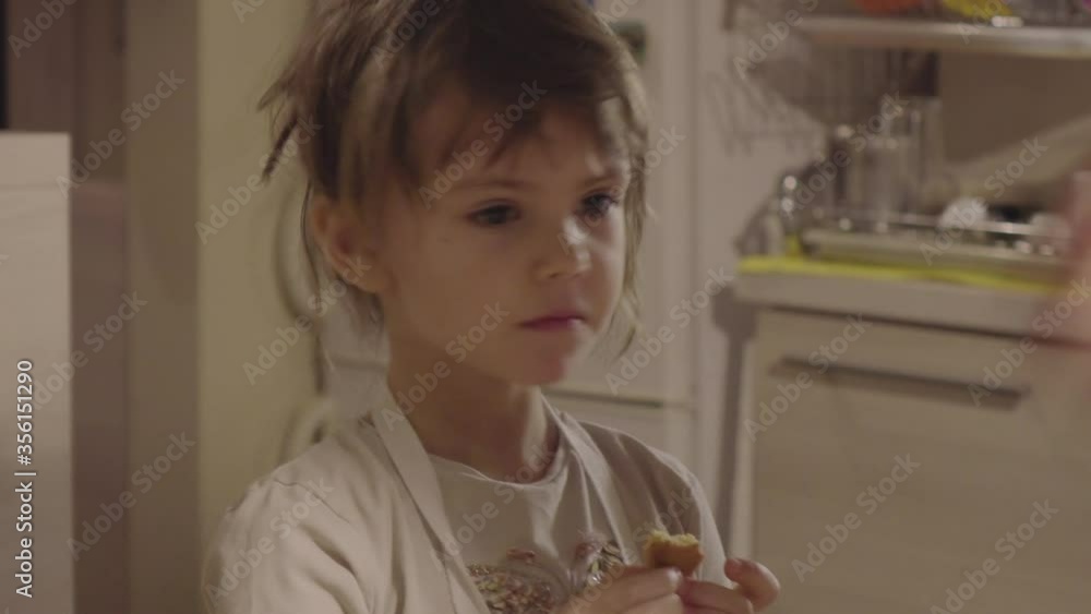 Charming little girl making biscuits at the kitchen table Charming little girl making biscuits at the kitchen table